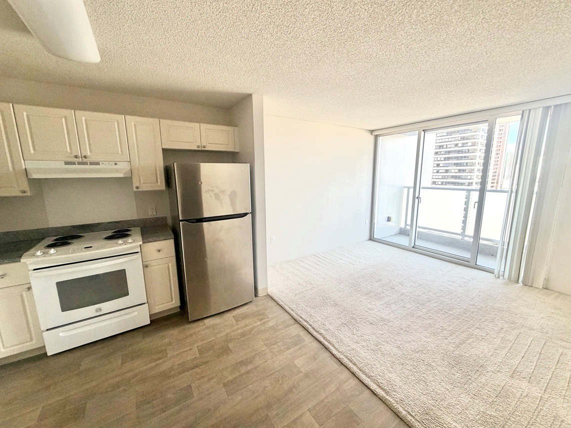 A kitchen with white appliances and wooden cabinets.
